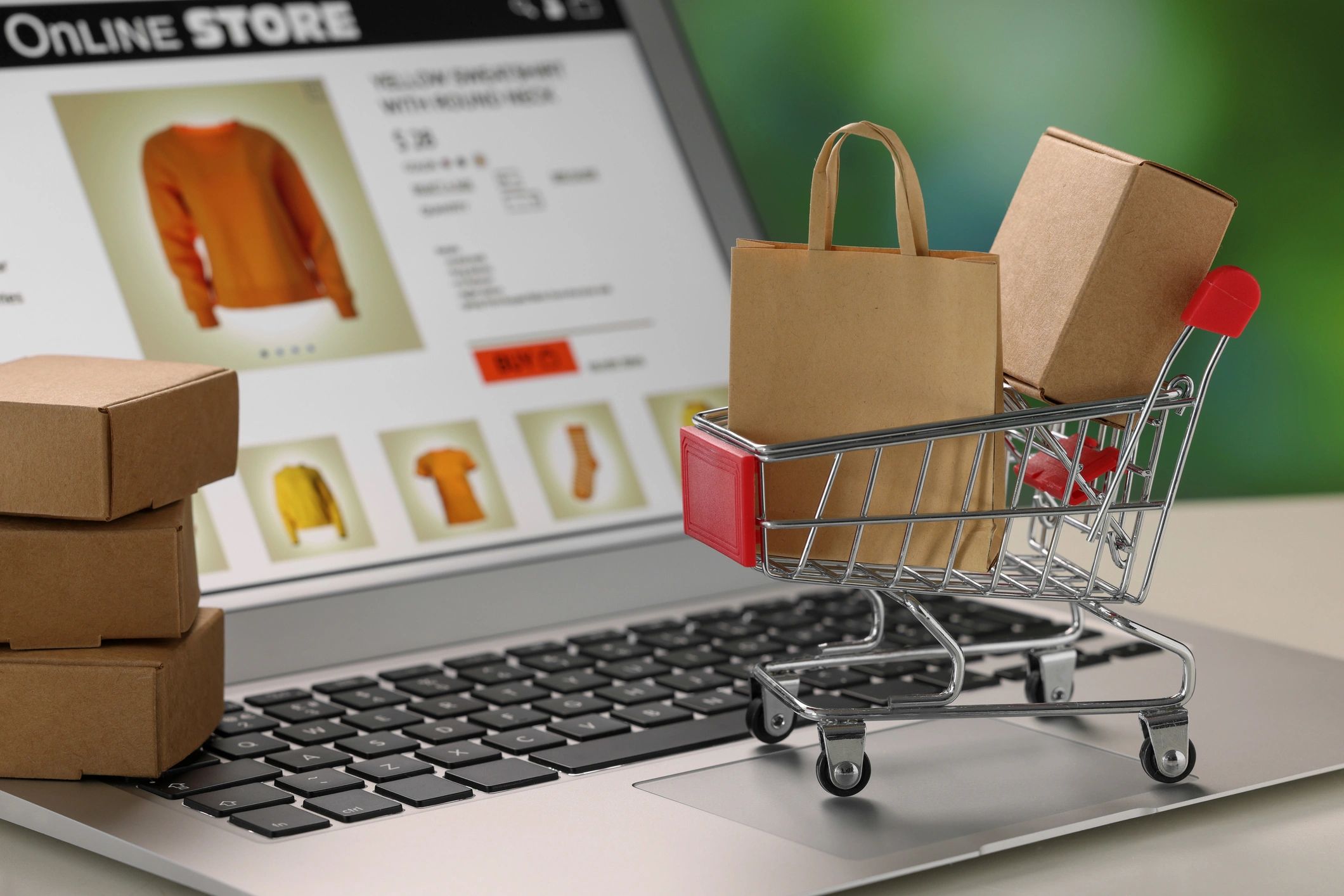 Online store concept with shopping cart and packages on a laptop